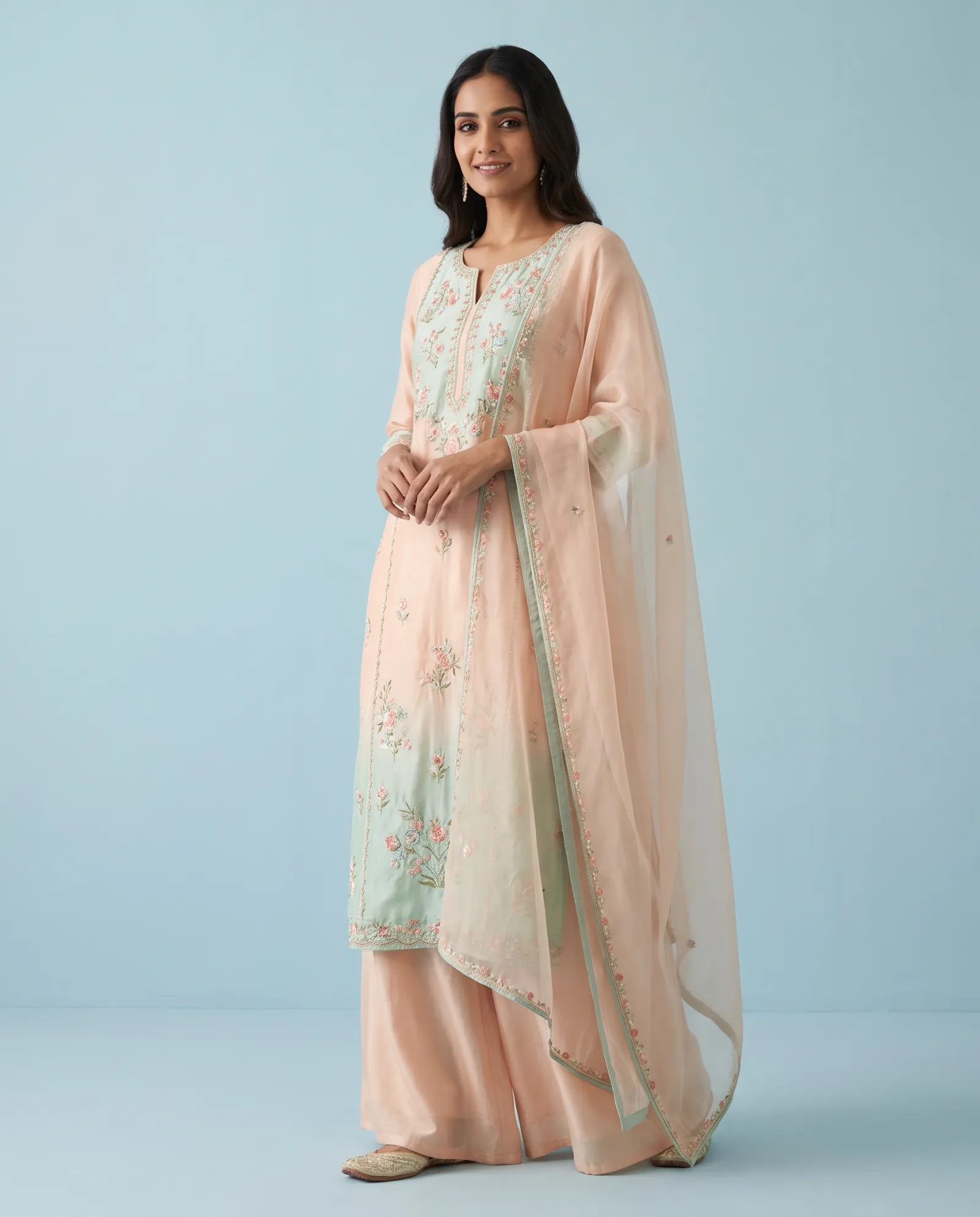 Model in a pastel embroidered kurta set against a powder-blue studio backdrop